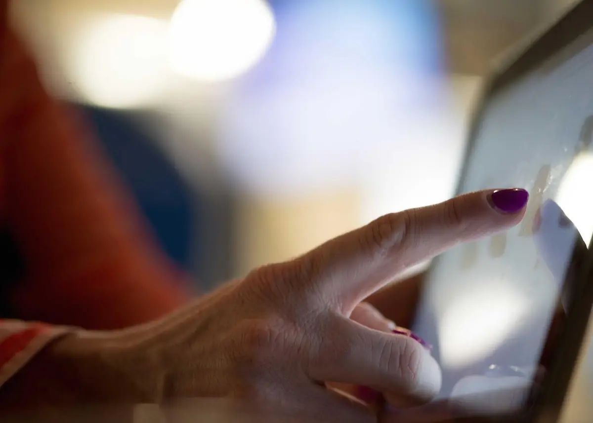 A finger tapping an order screen on a touchscreen tablet